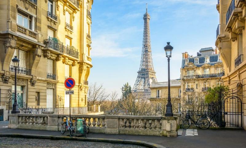 Façade d'un charmant hotel de Notre Dame Paris, avec ses balcons fleuris et son architecture haussmannienne typique